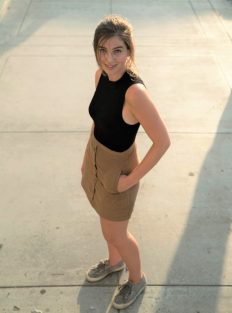 A photo of a young woman taken from above, from a fairly high angle. She looks slim as a result of the height of the camera. 