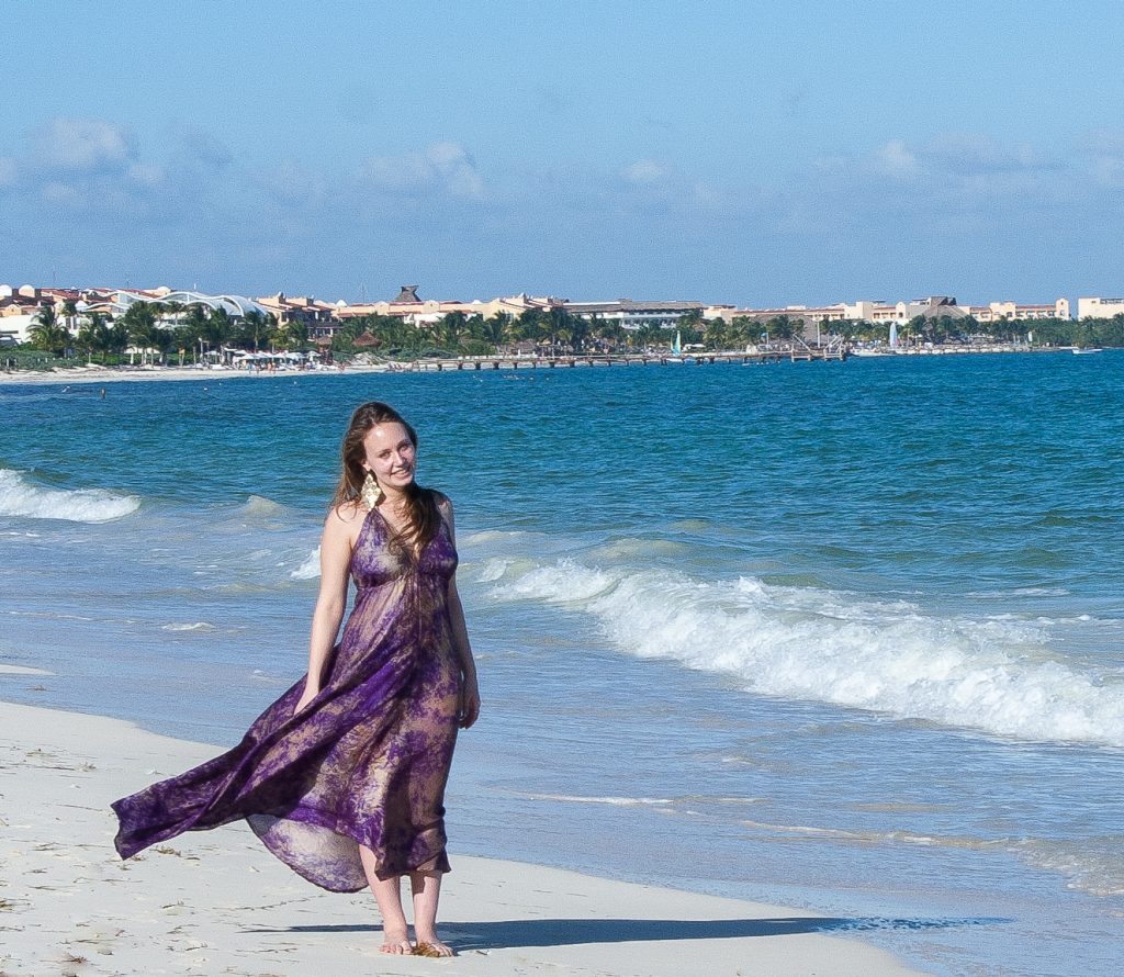 woman standing for a photo in the wind on the beach